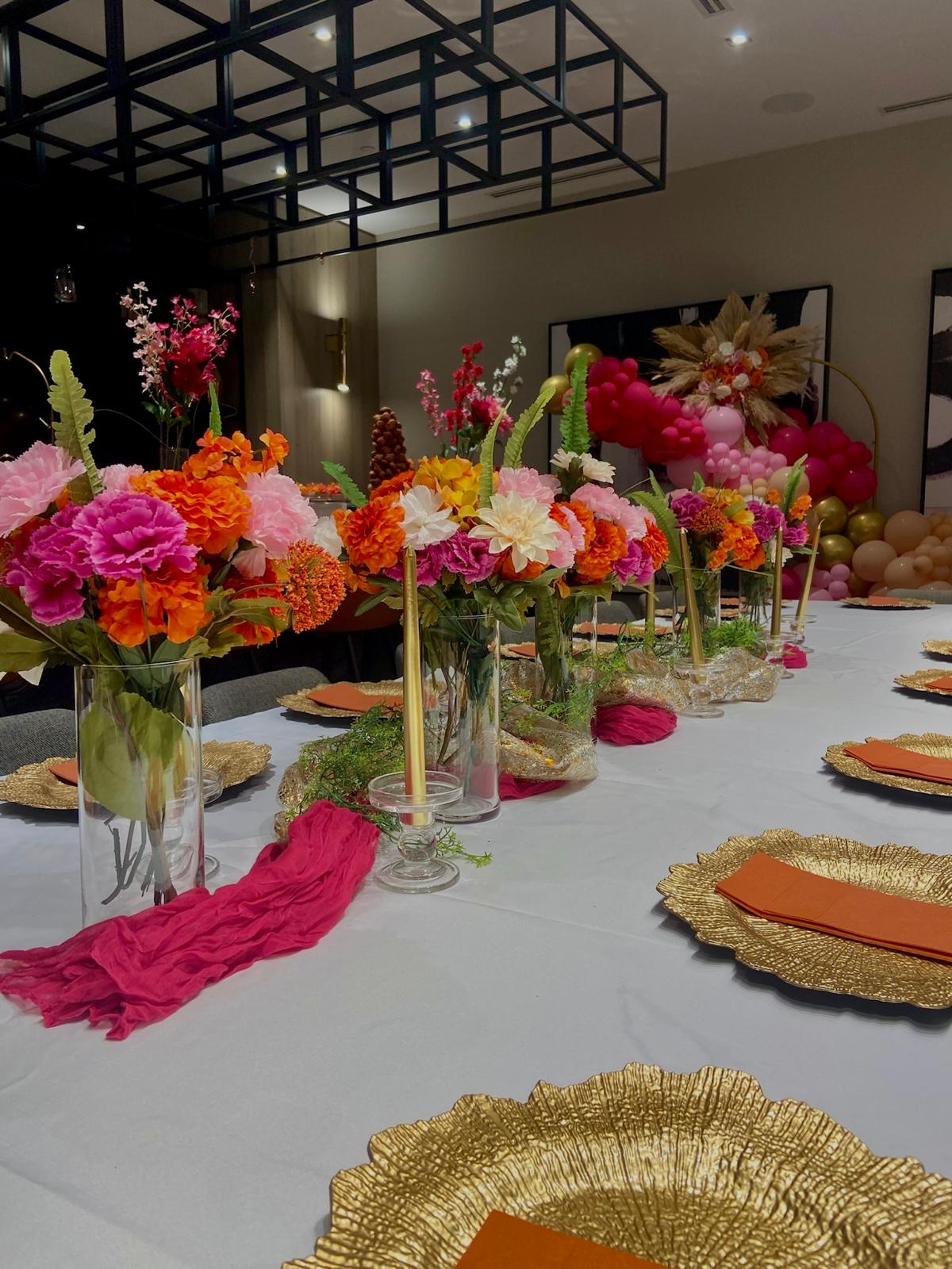 Pink and orange floral centrepieces with gold chargers